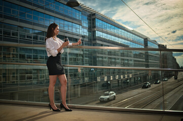 Businesswoman talking at her smartphone on a pedestrian bridge