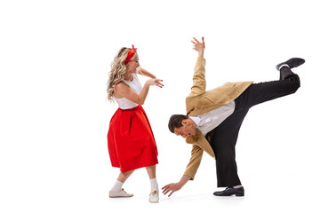 Excited young couple of dancers in vintage retro style outfits dancing social dance isolated on white background. Art, music, fashion, style concept