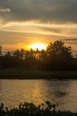 Naklejka premium Golden sky above Tha Chin river(Maenam Tha Chin),Nakhon Pathom,Thailand during sunset