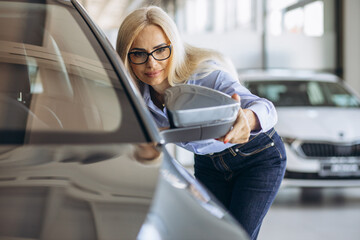 Buisness woman choosing a car in a car showroom