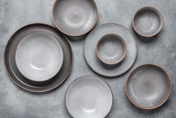Handmade ceramics, empty gray craft plates. Gray grunge background. Top view.