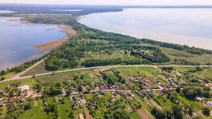 Aerial view of lake and small village. Village near the lake. Aerial view of the village and trees on the shore of lake.