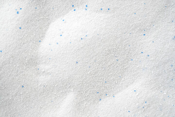 Сrumbly white washing powder as texture or background, top view