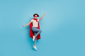Full length photo of funny cute lady dressed red mantle jumping high empty space isolated blue...
