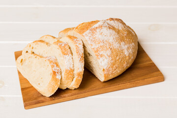 Assortment of freshly sliced baked bread with napkin on rustic table top view. Healthy unleavened bread. French bread slice