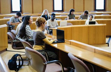 Young students working with laptop computers inside classroom at school university - Focus on front...