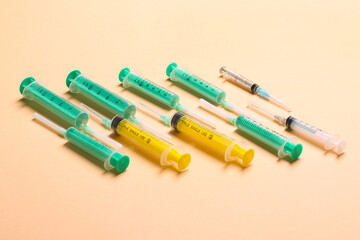 Top view of different syringes at orange background. Medical injection concept with copy space