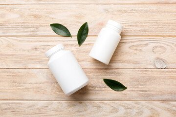 Fototapeta na wymiar supplement pills with medicine bottle health care and medical top view. Vitamin tablets. Top view mockup bottle for pills and vitamins with green leaves, natural organic bio supplement, copy space