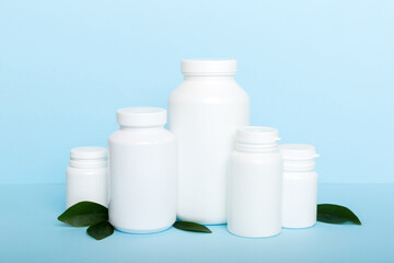 supplement pills with medicine bottle health care and medical top view. Vitamin tablets. Top view mockup bottle for pills and vitamins with green leaves, natural organic bio supplement, copy space