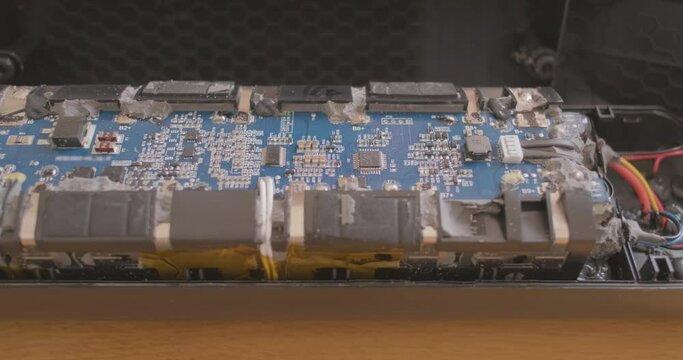 disassembled battery controller. Circuit board, flashing diode. Inspection of inside high-voltage battery. Concept repair, disassembly, technology.