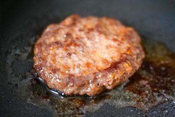 big and juicy burger cutlet fried on metal pan