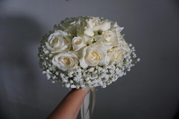 a white rose that symbolizes the sincerity of love is held by a woman