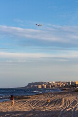 Playa de Urbanova mientras pasa un avión por encima, en Alicante