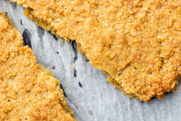 クッキングシートの上の焼きたてオートミールクッキー
