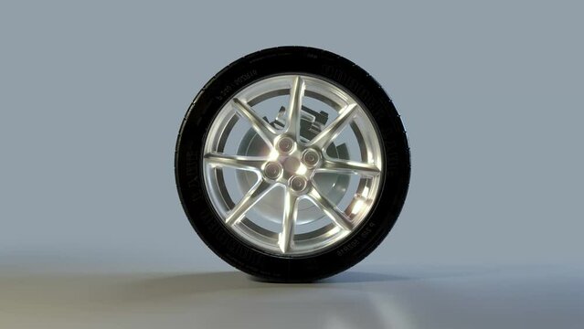 Side on view of a 3D wheel rolling across the screen. Standard black, rubber tyre and wheel rim in a continuous spin. Footage with a luma matte for isolating the object.
