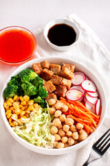 Vegan buddha bowl with tofu, colorful vegetables on base of brown rice.