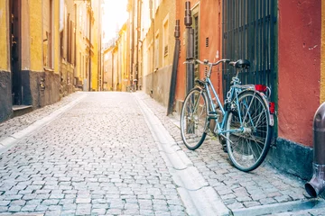 Fotobehang Uitstekende fiets in oude geplaveide straat van Stockholm © pyty