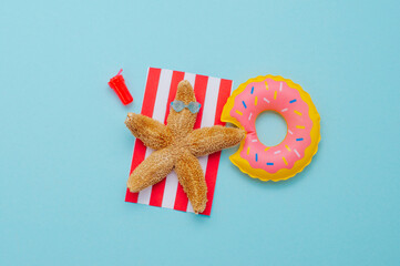 Starfish resting on the beach near donut shaped inflatable swim ring