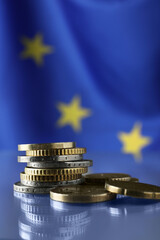 Fototapeta na wymiar Coins on table against European Union flag, closeup. Space for text