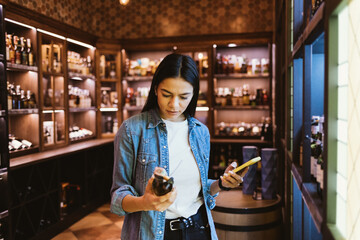 Portrait of young woman buying wine in an liquor store