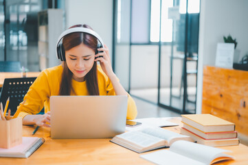  young student wearing headphones studies online, distance learning, and keeps up to date on the global coronavirus pandemic.