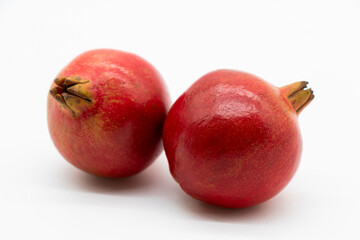Fresh whole pomegranate closeup isolated on white background