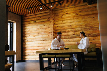 Man and woman drinking tea after sauna