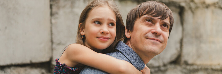 man dad having quality time with their kid daughter girl nine year old on his back. happy father playing with child. real life authentic day-to-day fatherhood moments. fatherly love care. banner
