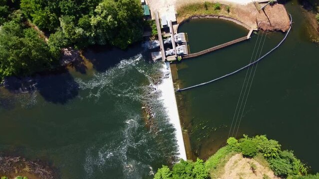 Petit barrage vu du dessus avec une eau qui s&rsquo;&eacute;coule en cascade. Retenue d&rsquo;eau artificielle dans un rivi&egrave;re naturelle.