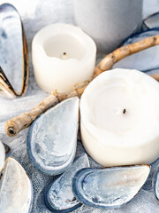 Inspirational marine style background with candles and mussels shells.Summer romantic evening idea. Pastel coloured  beach themed wedding table setting. Shallow depth of field.