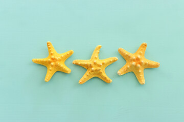 Fototapeta na wymiar nautical concept starfish over mint blue wooden background