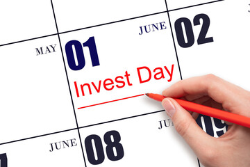 Hand drawing red line and writing the text Invest Day on calendar date June 1. Business and...