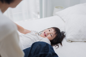 パパと一緒にベッドで遊ぶ小さな女の子