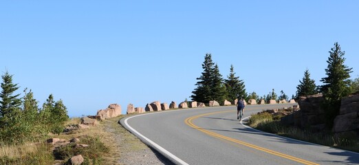 biking uphill on a curve mountain road - 512797282