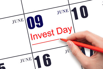 Hand drawing red line and writing the text Invest Day on calendar date June 9. Business and...