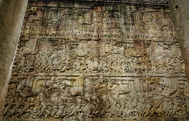 The sandstone bas-reliefs tell the stories of armies and wars. On the wall of Siem Reap Bayon Temple, Cambodia