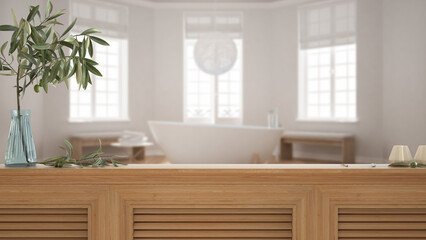 Wooden table top, cabinet, panel or shelf with shutters close up. Olive branch in vase and candles. Blurred background with white scandinavian bathroom with bathtub, interior design
