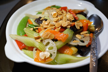 Stir fried vegetable with snow peas, celery, almond, bell pepper, lotus root, carrot and black fungus. Vegetarian food.