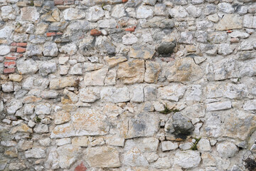 beautiful vintage texture of the wall of a medieval castle built in the middle of the 14th century, multi-colored volumetric stones for the designer, wallpaper, background