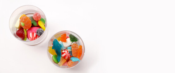 Jelly candies in two glasses on background with copy space, top view