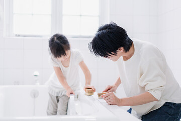 パパと一緒にお風呂掃除をする小さな女の子 - obrazy, fototapety, plakaty