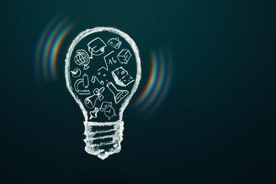 idea and eduction concept. Light bulb with hand drawn school doodle icons and light effects. Studying, knowledge, learning idea. Cpy space.