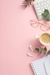 Business concept. Top view vertical photo of workspace keyboard cup of hot drinking pen open copybook glasses wireless earbuds and eucalyptus on isolated pink background with copyspace