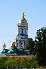 Fototapeta na wymiar Gold domed Bell tower of Kyiv Pechersk Lavra. Blue sky background. Orthodox Christian monastery. UNESCO World Heritage Site. Scenic morning view