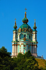 Fototapeta na wymiar Detailed view of ancient Saint Andrew's Church against blue sky, summer sunny morning. Architectural icon of the city of Kyiv. Christian Orthodox cathedral. UNESCO World Heritage Site