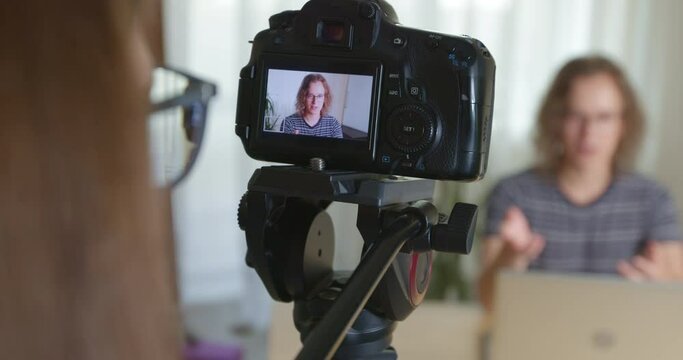 Shooting a video of a young man on a professional vlog camera.