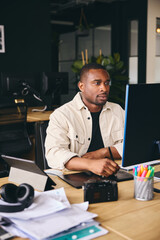 Young Black Male Advertising Marketing Or Design Creative In Modern Office Sitting At Desk Working...