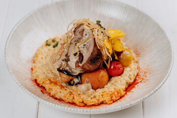 Meat roll with prunes is served on a pillow of vegetables and rice in restaurant