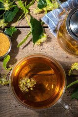 Herbal linden flower tea. linden green tea in glass teapot and tea cup, with fresh linden blossom