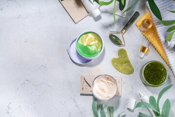 Nature anti-aging cosmetics, therapy massage. Asian beauty skin care. Jade roller, gua sha massager with various organic serum, gel, herbal extract, spa towels. Flatlay on white marble background